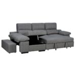 Sofá gris con chaise longue, en la imagen se muestra la parte del almacenamiento abierto bajo el asiento, y los reposabrazos levantados. Hay también dos taburetes o puff extraíble a un lado del sofá.