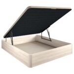 Base de cama abatible, con el mecanismo de apertura hidráulica levantado. La estructura de la base es de un color madera clara, y la tapa tiene un revestimiento de color oscuro en la parte inferior. Este diseño proporciona un amplio espacio de almacenamiento en el interior de la base.