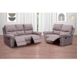 Conjunto de sofás reclinables de dos y tres plazas modelo América en color cemento, con mecanismo de palanca para mayor comodidad. Perfecto para una sala de estar moderna, con suelo de madera y decoración contemporánea. La tela antimanchas y antiácaros garantiza durabilidad y fácil mantenimiento, creando un espacio acogedor y limpio.