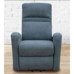 Sillón reclinable Condal de color gris azulado con respaldo alto y diseño ergonómico, tapizado en tela resistente. Ideal para proporcionar comodidad en una sala de estar, con un fondo de pared de ladrillo blanco que resalta su estilo contemporáneo.