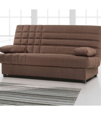 Sofá cama en posición de sofá, de color marrón chocolate, con sistema click-clack y cojines a juego. El sofá está ubicado en una habitación moderna con suelos brillantes de color claro y una gran alfombra de rayas en tonos grises y blancos. La habitación cuenta con grandes ventanales que dejan entrar mucha luz natural.