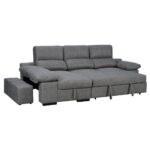 Sofá grande de color gris con chaise longue y cojines acolchados, extendido en una posición de cama. Incluye un reposapiés extraíble en el lado izquierdo.