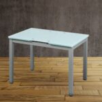 Mesa de comedor moderna con superficie de vidrio templado y estructura metálica en color gris, ideal para comedores contemporáneos. La mesa se destaca por su diseño minimalista y elegante.