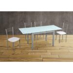 Mesa de comedor extensible con superficie de vidrio templado y cuatro sillas con cojines blancos. Dimensiones ajustables para adaptarse a diferentes necesidades de espacio en comedores modernos.